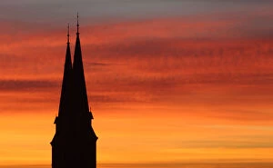 Images Dated 4th October 2012: Spires of Familienkirche are silhouetted against sky during sunrise in Vienna