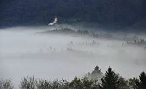 St. Margaret church is seen out of evening fog in the village of Zlebe St. Margaret church is seen out of evening fog in the village of Zlebe