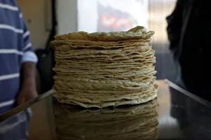 Stack of freshly made corn tortillas is weighted at a tortilla factory in Mexico City Stack of freshly made corn tortillas is weighted at a tortilla factory in Mexico City