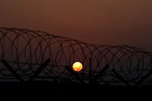 Images Dated 9th January 2018: The sun rises over a barbed-wire fence at a checkpoint on the Grand Unification Bridge in
