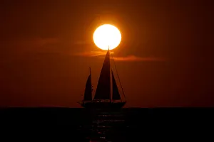 The sun sets behind the British-flagged NGO Proactiva Open Arms rescue boat Astral as it The sun sets behind the British-flagged NGO Proactiva Open Arms rescue boat Astral as it