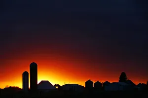 The sun sets over a silhouette of a farm corn silo outside of Rock Rapids The sun sets over a silhouette of a farm corn silo outside of Rock Rapids