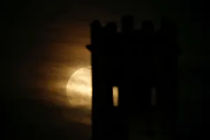 A supermoon full moon rises behind the guard tower on the 17th century San Salvatore A supermoon full moon rises behind the guard tower on the 17th century San Salvatore