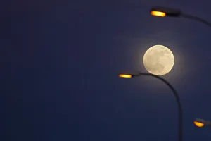 The supermoon full moon is seen rising behind street lights in Ronda The supermoon full moon is seen rising behind street lights in Ronda