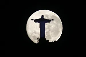 The supermoon is pictured behind the Christ the Redeemer statue in Rio de Janeiro The supermoon is pictured behind the Christ the Redeemer statue in Rio de Janeiro