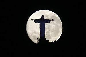 Images Dated 11th August 2014: The supermoon is pictured behind the Christ the Redeemer statue in Rio de Janeiro