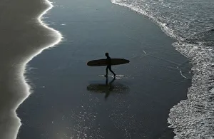 Surfer heads home after riding the morning waves in Oceanside, California Surfer heads home after riding the morning waves in Oceanside, California