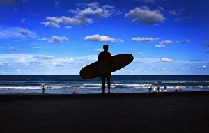 A surfer holds his board as he looks over Manly Beach in Sydney A surfer holds his board as he looks over Manly Beach in Sydney