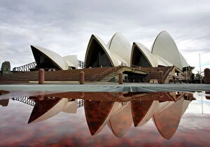 Images Dated 31st March 2005: Sydneys landmark Opera House is reflected in a pool of rain water March 31, 2005