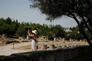 Ancient Greek Architecture Collection: A tourist takes pictures with her phone as she visits the Roman Agora archaeological site