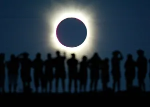 Tourists watch the sun being blocked by the moon during a solar eclipse in the Australian outback Tourists watch the sun being blocked by the moon during a solar eclipse in the Australian outback