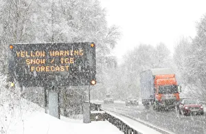 Traffic passes a road sign warning of adverse weather conditions on the A9 near Traffic passes a road sign warning of adverse weather conditions on the A9 near