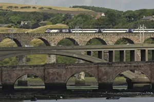 A train crosses the Royal Border Bridge, as fishermen are seen catching salmon in A train crosses the Royal Border Bridge, as fishermen are seen catching salmon in