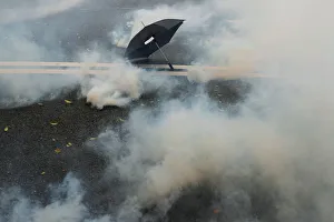 An umbrella lies on the ground surrounded by the mist of tear gas during a demonstration An umbrella lies on the ground surrounded by the mist of tear gas during a demonstration