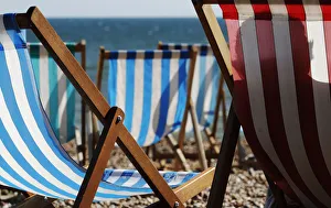 A vendor renting deck chairs dozes in the sun in Brighton, southern England A vendor renting deck chairs dozes in the sun in Brighton, southern England
