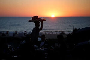Images Dated 29th August 2019: A vendor sells candied apples during the sunset on the beach in Gaza City