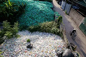A Vietnamese woman drives past recyclable plastic bottles at Xa Cau village outside Hanoi A Vietnamese woman drives past recyclable plastic bottles at Xa Cau village outside Hanoi