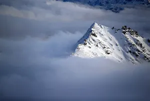 A view of a cross on a summit of the Goldberg group mountains as fog rises, seen A view of a cross on a summit of the Goldberg group mountains as fog rises, seen