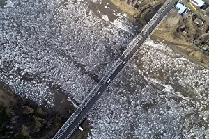 A view shows vehicles driving along a bridge across the Mana River during an ice drift A view shows vehicles driving along a bridge across the Mana River during an ice drift
