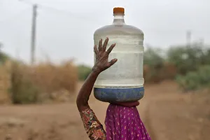 Village woman carries container filled with drinking water supplied by the government-run Village woman carries container filled with drinking water supplied by the government-run