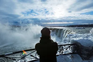 A vistor takes pictures of ice covered Niagara Falls in Niagara A vistor takes pictures of ice covered Niagara Falls in Niagara