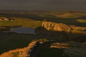 A walker looks north towards Scotland in late evening sun at Hadrians Wall near Crag A walker looks north towards Scotland in late evening sun at Hadrians Wall near Crag
