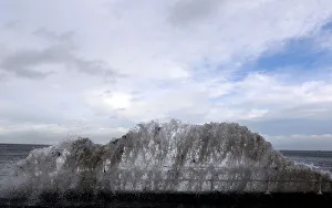 Waves crash against the coastal wall in the village of Carnlough as high tides Waves crash against the coastal wall in the village of Carnlough as high tides