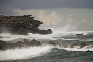 Waves hit a cliff on a rainy afternoon at Coogee beach in Sydney Waves hit a cliff on a rainy afternoon at Coogee beach in Sydney