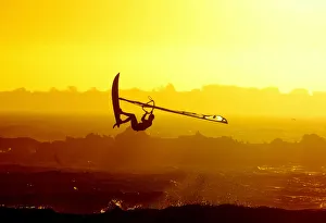 WINDSURFERS GETS AIRBOURNE AS THE SUN SETS ON CAPE TOWN'S BLAAUBERG BEACH WINDSURFERS GETS AIRBOURNE AS THE SUN SETS ON CAPE TOWN'S BLAAUBERG BEACH
