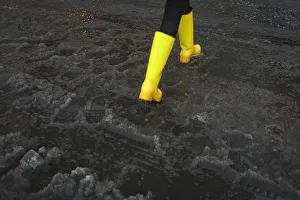 A woman with bright yellow boots walks though puddle of slush in Times Square during A woman with bright yellow boots walks though puddle of slush in Times Square during