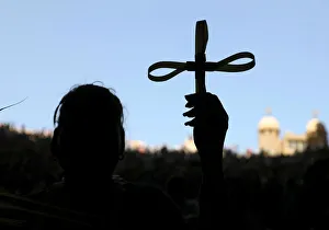 A woman holds a cross during a Coptic Orthodox Palm Sunday mass at the Samaan el-Kharaz A woman holds a cross during a Coptic Orthodox Palm Sunday mass at the Samaan el-Kharaz