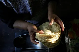 Woman holds freshly made corn tortillas at a tortilla factory in Mexico City Woman holds freshly made corn tortillas at a tortilla factory in Mexico City