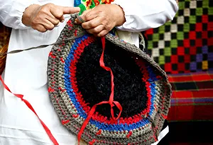 A woman knits a rug as she takes part in Beraginya festival of folklore art in the town A woman knits a rug as she takes part in Beraginya festival of folklore art in the town