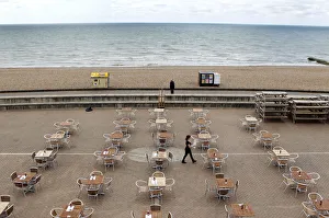 A woman places menus on tables outside a restaurant on the seafront in Brighton A woman places menus on tables outside a restaurant on the seafront in Brighton