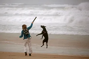 Images Dated 5th January 2018: A woman plays with her dog during a storm in Zikim beach