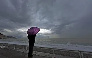 A woman protects herself under an umbrella during an autumn day on the Promenade Des A woman protects herself under an umbrella during an autumn day on the Promenade Des