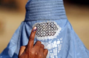 Images Dated 11th February 2017: A woman shows her ink marked finger after voting during the state assembly election