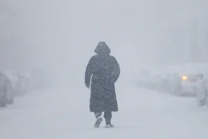 Images Dated 5th January 2018: A woman walks down the street during a blizzard in Long Beach