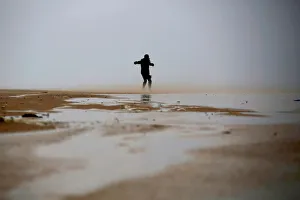 Images Dated 5th January 2018: A woman walks against the wind during a storm in Zikim beach