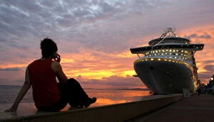 Port of Spain Gallery: A woman watches the sunset at the Summit of the Americas in Trinidad