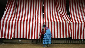A woman wearing a traditional Sevillana dress looks into a stall at a fair in Seville A woman wearing a traditional Sevillana dress looks into a stall at a fair in Seville
