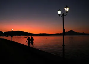 Two women walk by the sea during sunrise in Raches village Two women walk by the sea during sunrise in Raches village