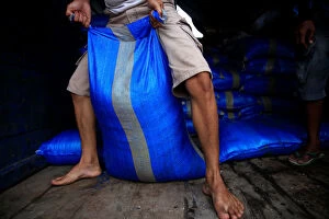 Indonesia Gallery: A worker drags a sack of industrial salt at a warehouse in Jakarta
