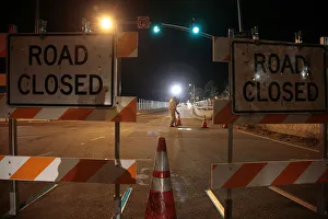 A worker places traffic cones on the road as the Mulholland bridge is closed over the 405 A worker places traffic cones on the road as the Mulholland bridge is closed over the 405
