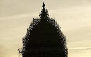 Images Dated 4th December 2014: A worker reaches for supplies while working atop the scaffolded dome of the U.S