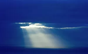 Sun poking through clouds at dusk over North Sea Shetland