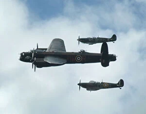 Battle of Britain Collection: 2011 Goodwood Revival Lancaster bomber and 2 Spitfires in aerial display