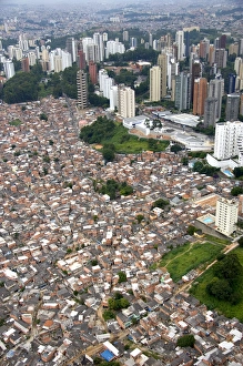 Aerial view of crowded favela housing contrasts with modern apartment buildings in Sao Aerial view of crowded favela housing contrasts with modern apartment buildings in Sao