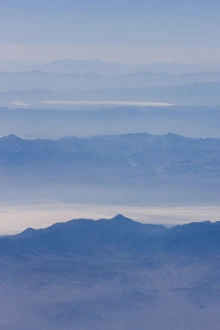 An aerial view of smoke covered mountain peaks and valleys in eastern California An aerial view of smoke covered mountain peaks and valleys in eastern California
