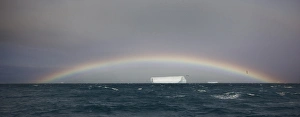Antarctica, South Georgia, South Atlantic Ocean. A tabular iceberg floats under a low Antarctica, South Georgia, South Atlantic Ocean. A tabular iceberg floats under a low